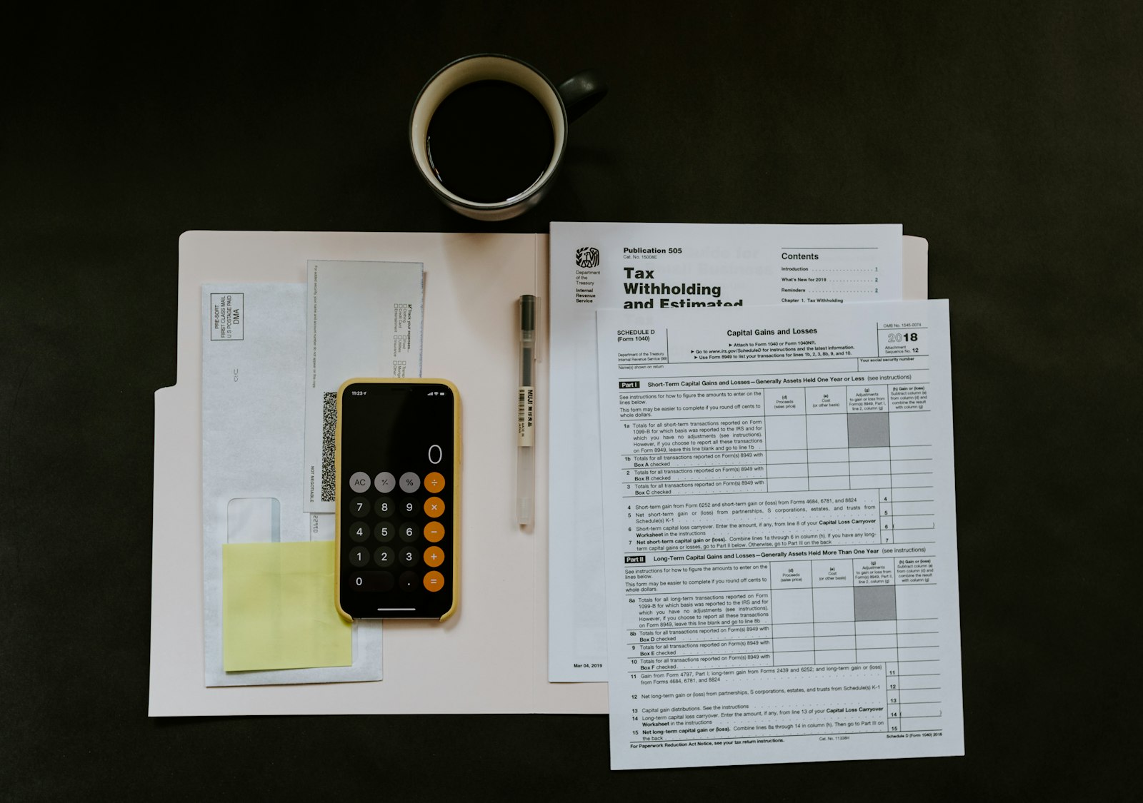 Documents fiscaux, stylo et calculatrice posés sur un bureau