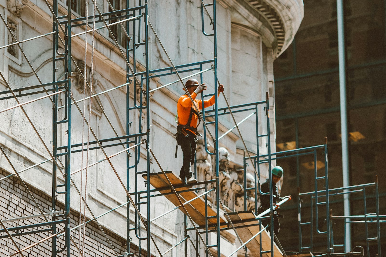 Ouvriers sur une échelle le long d'une façade en travaux